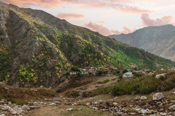 landscape of mountain village in summer along green hills of Astore Valley Pakistan during sunset