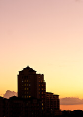 front view, far distance of a tropical, silhouetted, building at sundown 