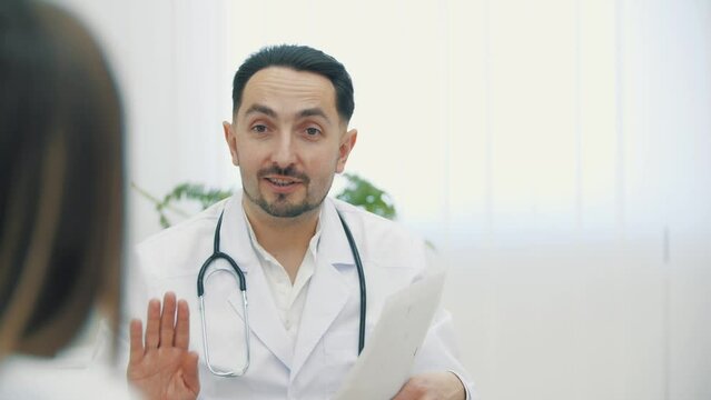4k video of doctor wearing white lab coat speaking with a patient.