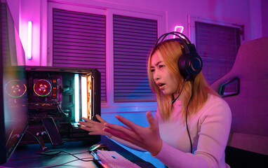 A Professional female pro gamer play online video games cyber sport and esport anger lose emotion. Young woman in tournament match worldwide in room colorful neon lights. © Kiattisak