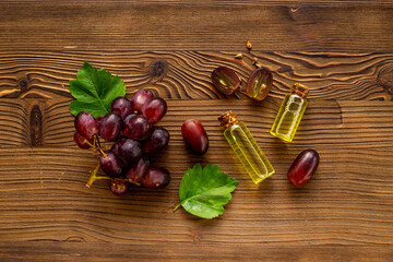 Fototapeta na wymiar Grape seed essential oil with bunch of grapes. Eco cosmetic product