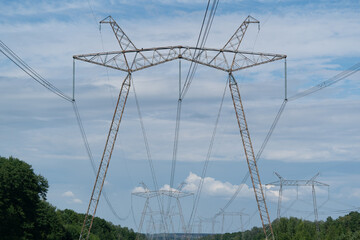 A photo of the  electrical high-voltage power line tower against the blue sky