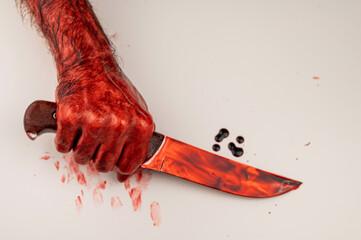 A man with bloody hands holds a knife on a white background. - obrazy, fototapety, plakaty