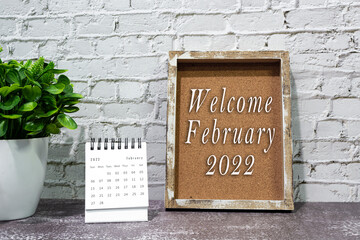 Welcome february 2022 text on wooden frame and February 2022 calendar.