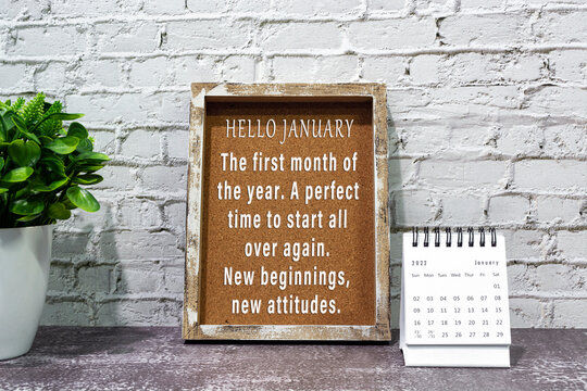 Inspirational and motivational quote on wooden frame and January 2022 calendar.