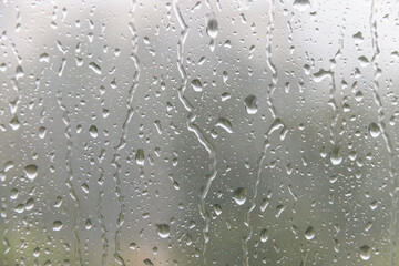 Raindrops run down the window pane. Rainy weather. Soft selective focus.