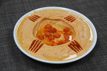 Spicy Hummus served in a dish isolated on wooden table background side view of appetizer