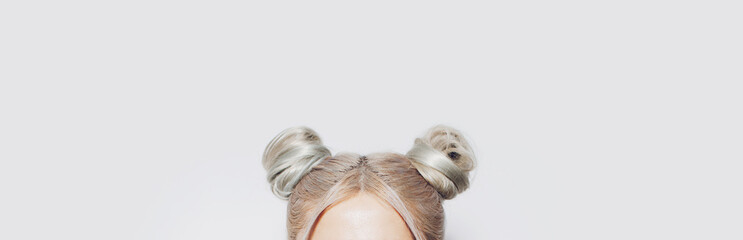 Close-up of two blonde hair buns. Panoramic banner view.
