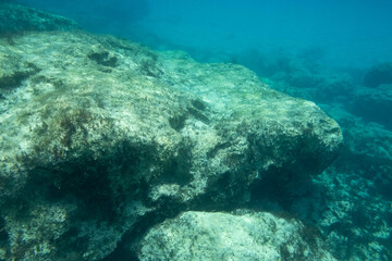 Naklejka na ściany i meble Unterwasser - Felsen in blauem Wasser