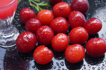 Cherry fruit on a black background with water drops - a beautiful background with organic food.