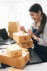 Business woman happy and cheerful for successful for receiving orders from customer via laptop with a lot of parcel boxes for shipping.