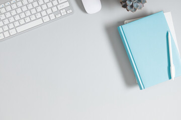 Gray office desk mockup, notepad, computer keyboard, plant. Flat lay, top view, copy space