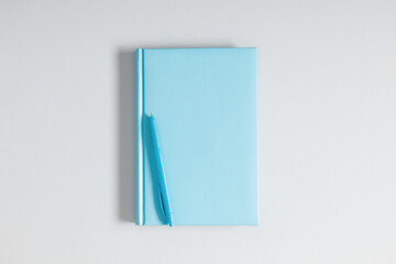 Blue notebook and pen on gray background. Education concept. Spiral notepad and pen. Flat lay, top view, copy space