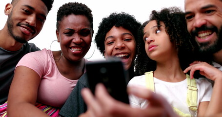 Diverse interracial family at home couch looking at cellphone