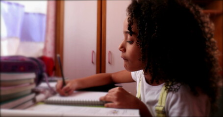 Fototapeta na wymiar Cute little school gir writing notes doing homework
