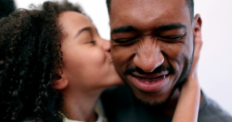 Cute little girl kissing older brother on the cheek, mixed race siblings