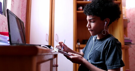 Child studying at home during quarantine in front of laptop computer