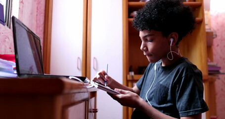 Child studying at home during quarantine in front of laptop computer