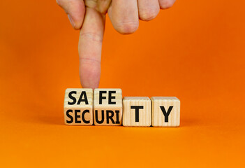 Safety and security symbol. Concept words Safety and security on wooden cubes. Businessman hand. Beautiful orange table orange background. Business safety and security concept. Copy space.