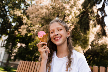 Funny child girl have fun with ice cream cone in waffle cup. Happy girl smiling, laughing and...