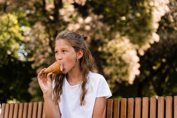 Funny child girl eating ice cream cone in waffle cup. Creative advert for ice cream stand and shop.