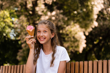 Funny child girl have fun with ice cream cone in waffle cup. Happy girl smiling, laughing and grimacing. Creative advert for ice cream stand and shop.