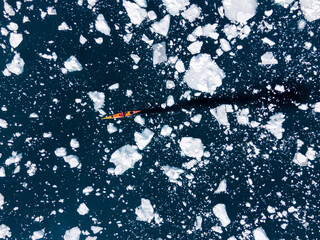 background kayak drifting in sea ice icebergs, greenland polar circle outdoor sports, kayaking in...