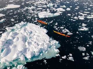 kayak next to a gigantic iceberg in ilulissat greenland outdoor sports kayaking along frozen icebergs in open sea water