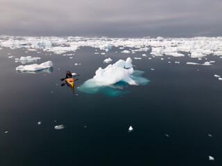 kayak next to a gigantic iceberg in ilulissat greenland outdoor sports portrait panoramic shot © Salvisberg