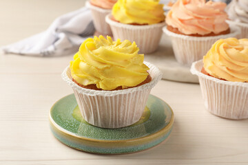 Tasty colorful cupcakes on white wooden table