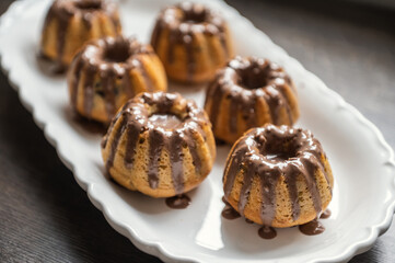 Coating with chocolate glaze muffins at birthday party