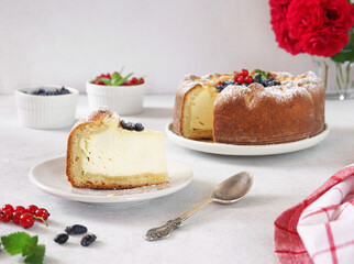 Homemade german cheesecake kasekuchen with berries on beautiful plate on table. Natural light, selective focus.