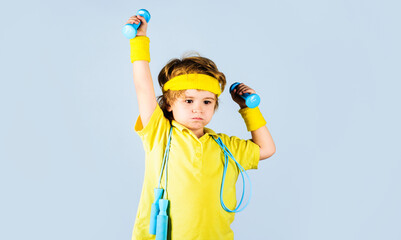 Sporty boy in sportswear with jumping rope and dumbbells. Sport equipment. Fitness, health, energy.