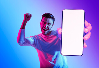 Online Offer. Excited Young Man Showing Blank Smartphone And Celebrating Success