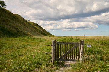 Holztor an einem Zaun vor den Hügeln der Issehoved an der Nordspitze der dänischen Ostsee Insel...