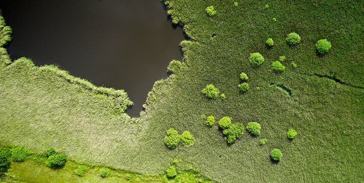 Luftaufnahme einer Naturfläche im Norden der dänischen Ostsee Insel Samsø mit grünen Wiesen, Bäumen und Wasser