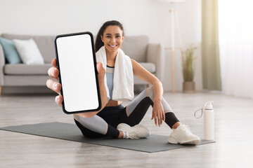 Fitness App. Happy Young Female Training At Home And Showing Blank Smartphone