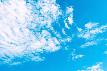 Obraz premium Light feather clouds in a bright blue sky. Blurred cloudy background.