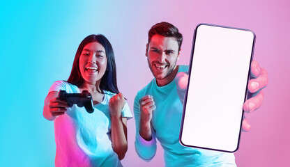 Cool App. Excited multiethnic gamer couple showing blank smartphone at camera © Prostock-studio