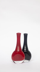 JARS OF RED AND BLACK NAIL PAINT ON A WHITE BACKGROUND WITH COPY SPACE