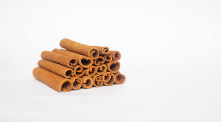 ORGANIC CINNAMON STACKED ON WHITE BACKGROUND WITH COPY SPACE