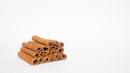 ORGANIC CINNAMON STACKED ON WHITE BACKGROUND WITH COPY SPACE