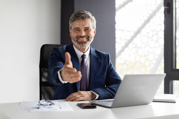 Smiling Middle Aged Businessman Extending Hand For Handshake At Camera