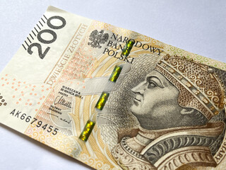 A 200 zloty bill in close-up on a white isolated background. Polish currency