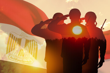 Double exposure of Silhouettes of soliders and the sunset or the sunrise against flag of Egypt....