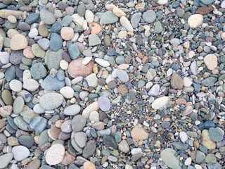 Large beach pebble. Background of small stones. Gray background from stones. Pattern.