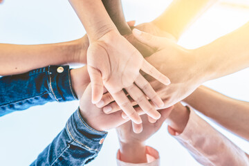 Close up view of young business people putting their hands together - Stack of hand - Unity and teamwork concept - Selective focus.