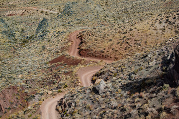 winding dirt road going up a vally