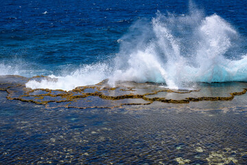 waves crashing on rocks and blow hole geyser