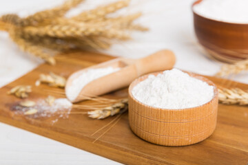 Flat lay of Wheat flour in wooden bowl with wheat spikelets on colored background. world wheat crisis